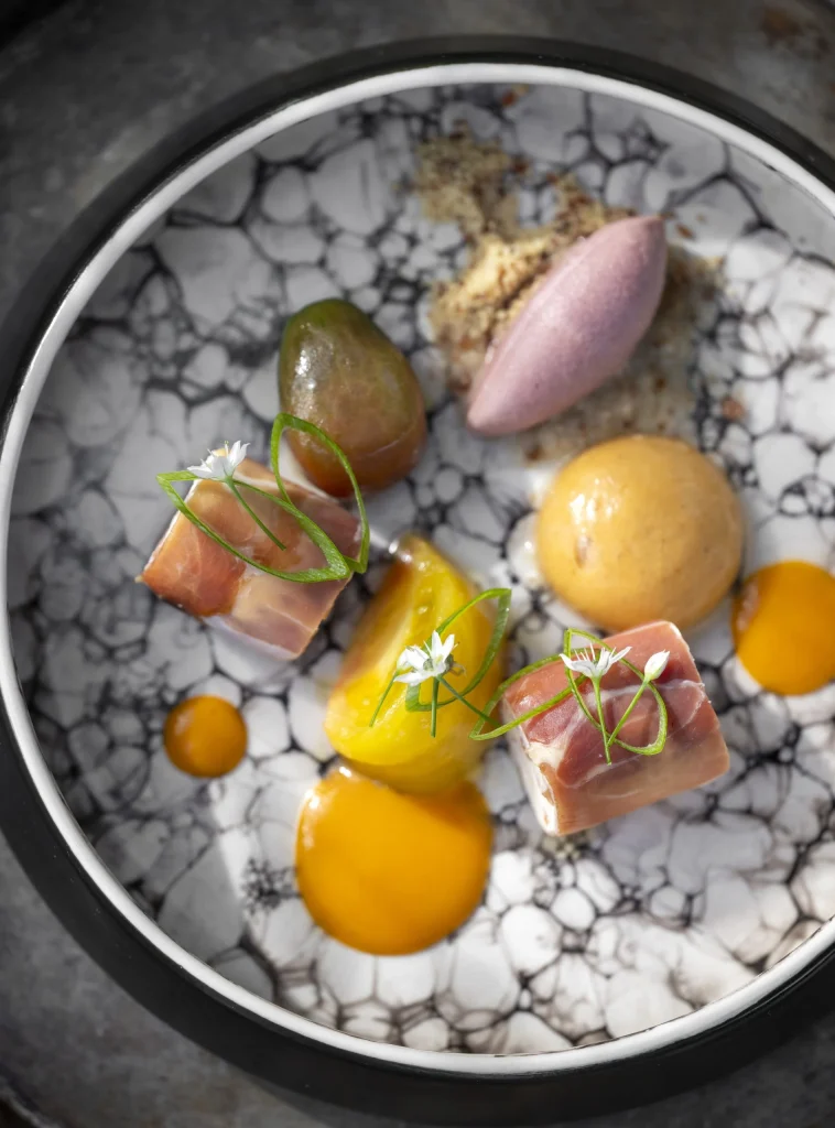 Entrée de saison dressée sur une assiette en céramique, fleurs du jardin