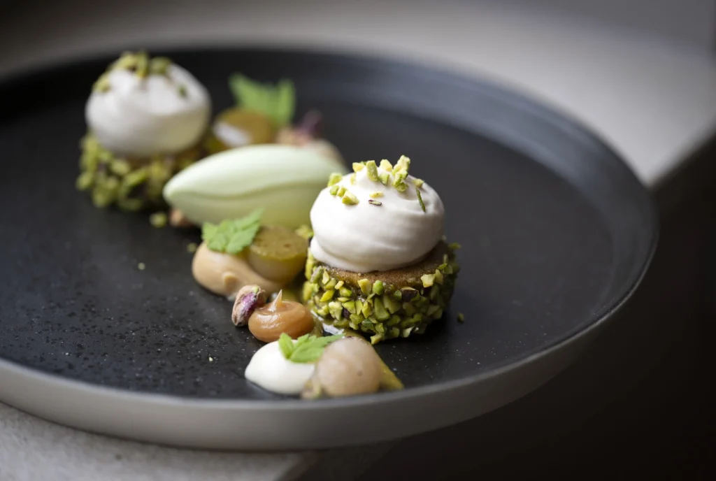 Dessert à la pistache sur assiette sombre