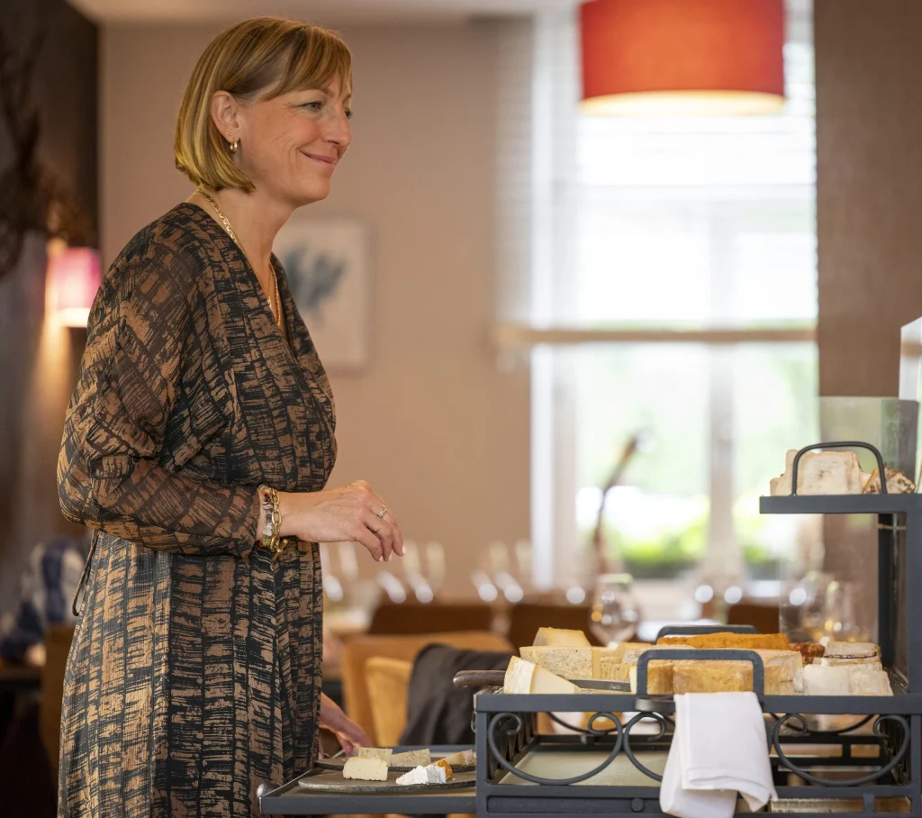 Véronique en salle, près du chariot de fromages
