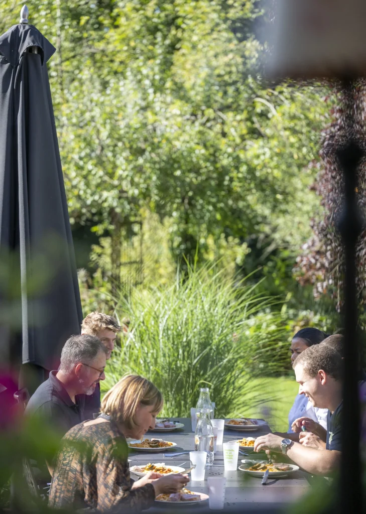 Olivier, Véronique et l'équipe à table dans le jardin