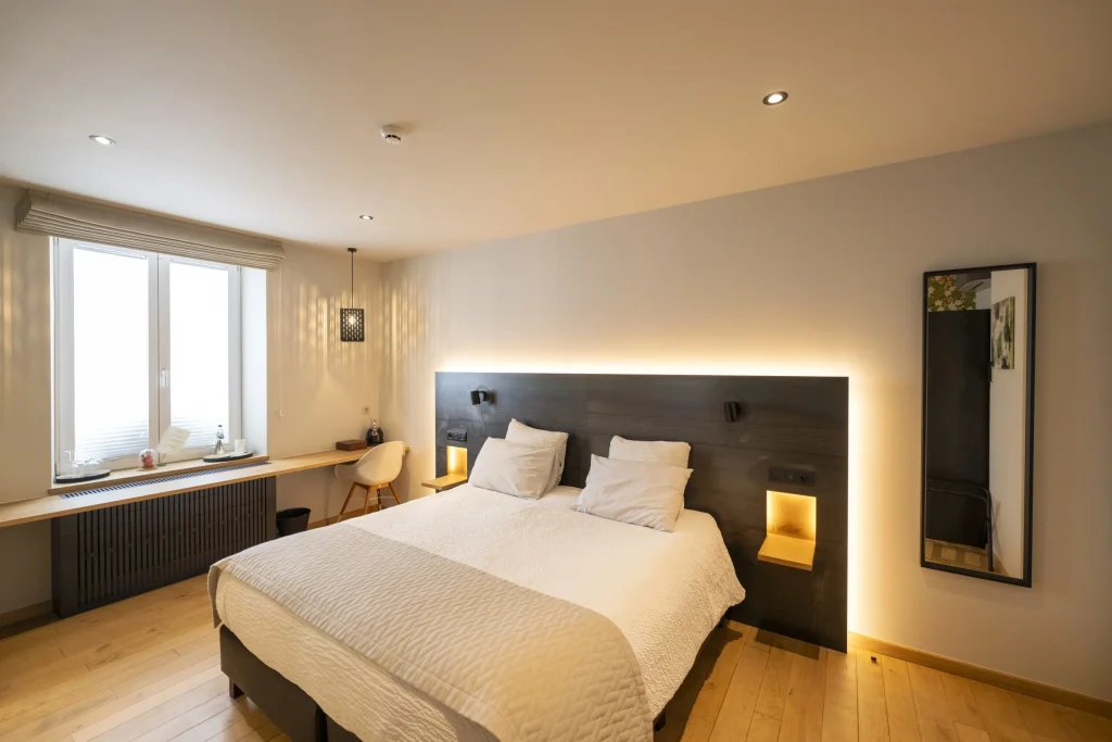 Chambre de l'hôtel, lit double et tête de lit éclairée