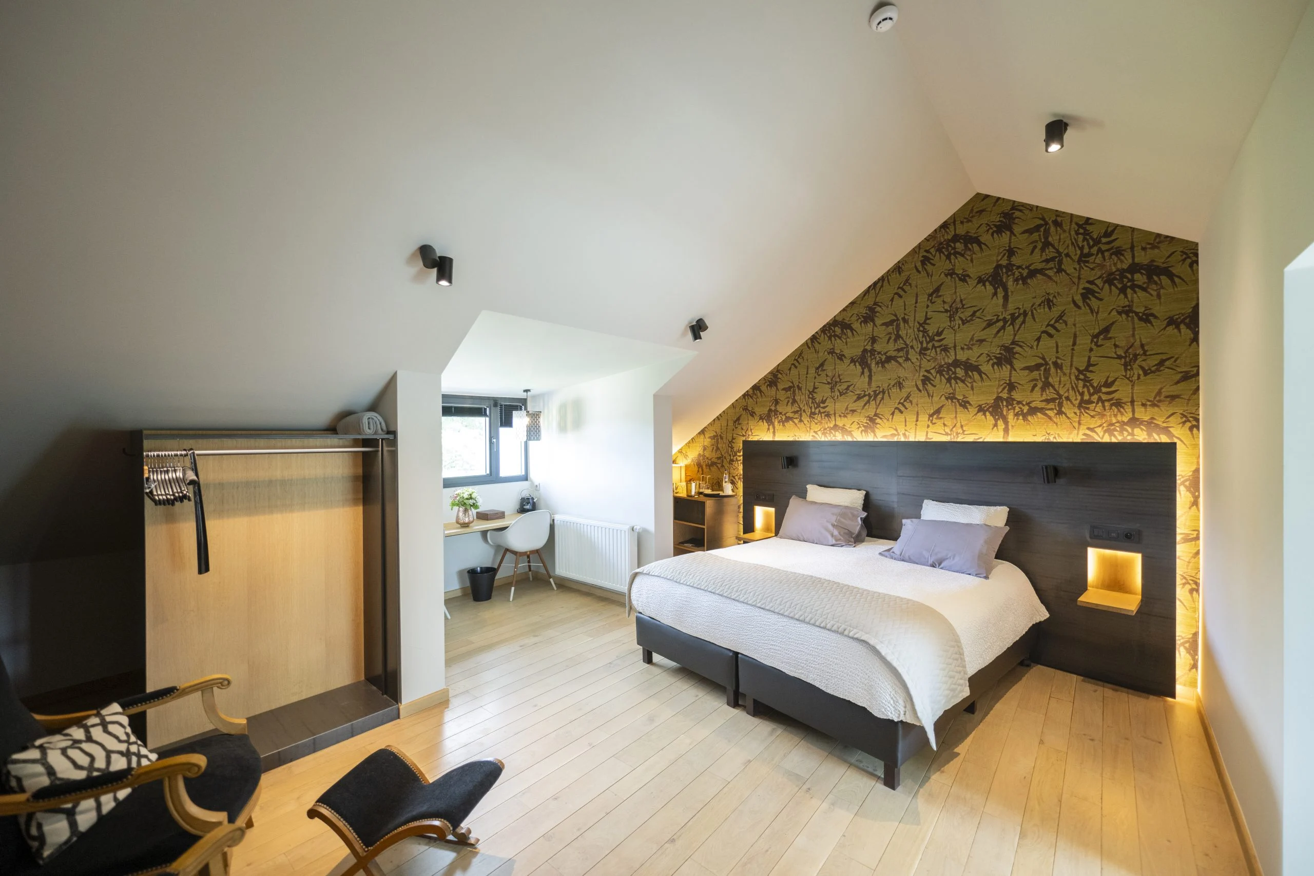 Chambre mansardée de l'hôtel, papier peint aux bambous et tête de lit éclairée